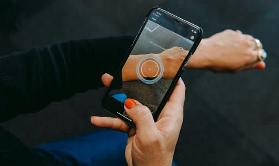 A woman using the SkinVision app to scan a mole on her arm